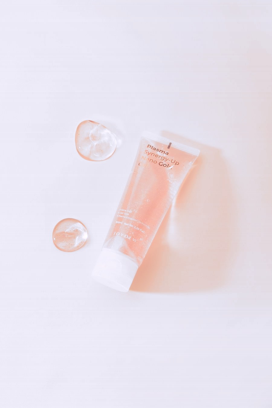 Nano Gold Gel tube laid flat beside two drops of gel