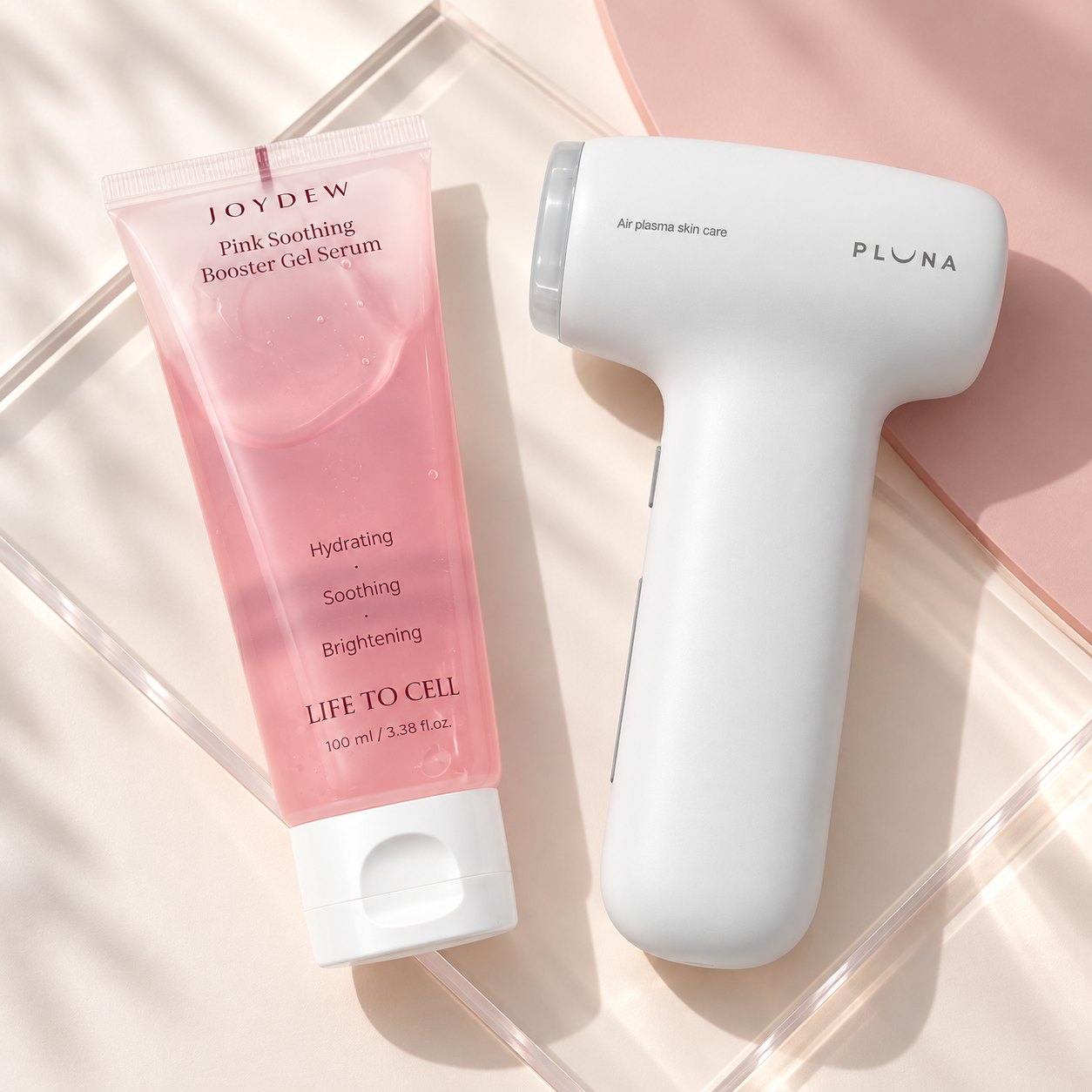 JOYDEW Pink Soothing Booster Gel Serum beside the PLUNA device